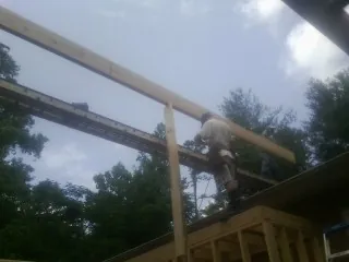 Carpenter setting a ridge beam over a new addition frame — Ice Dam Removal by Roofing Brothers in Willow Springs