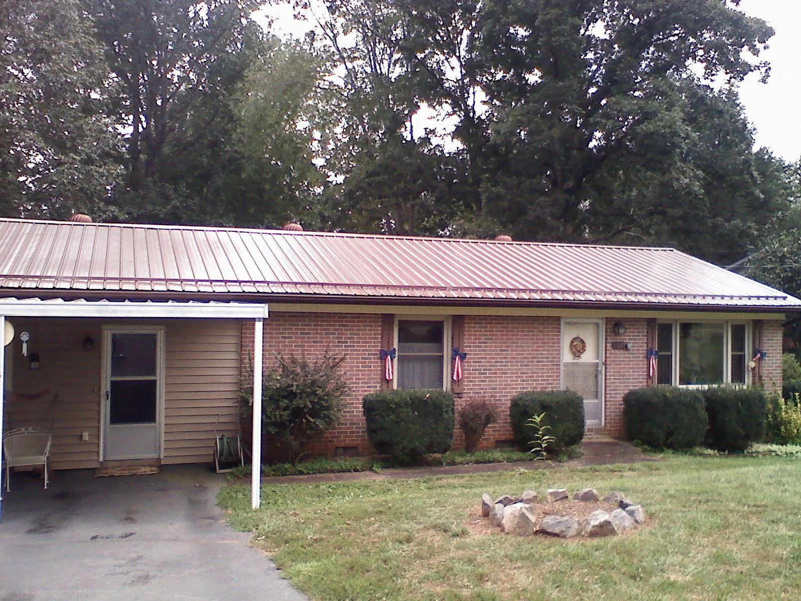 Bronze metal roof and carport on a brick ranch home — Roof Repair work by our crew in Willow Springs